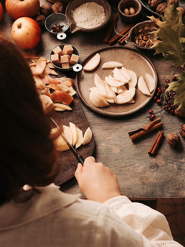fotografia lifestyle przedstawiająca kobiete krojącą jabłka