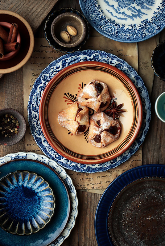 kolorowe naczynia do fotografii kulinarnej - na zdjęciu widoczne sa akcesoria takie jak talerze, miski, miseczki w odcieniach brązu i granatu